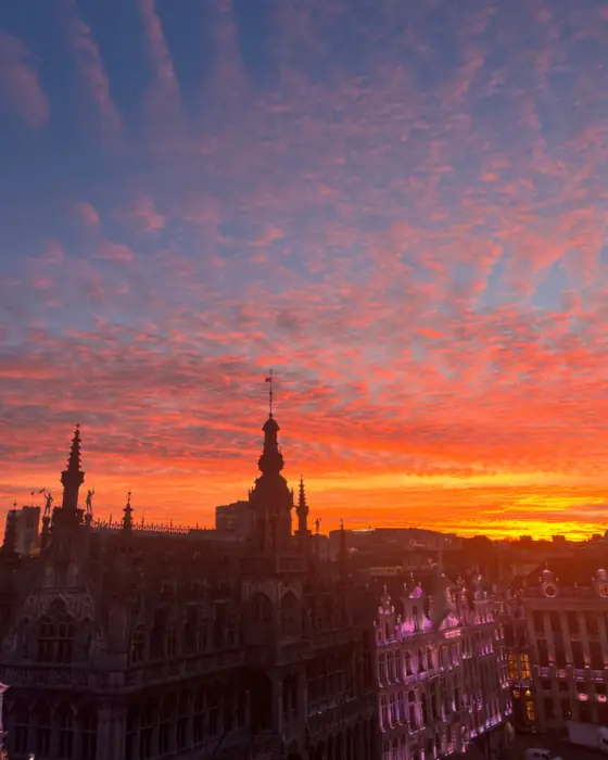 Les toits et la flèche de l'hôtel de ville de Bruxelles sous un ciel rouge